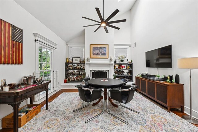 living room with high vaulted ceiling, ceiling fan, and hardwood / wood-style floors