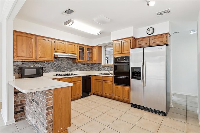 kitchen with decorative backsplash, black appliances, light tile patterned floors, and kitchen peninsula