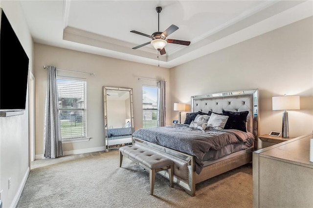 bedroom featuring light carpet, ceiling fan, and a raised ceiling