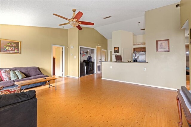 living room with high vaulted ceiling, ceiling fan, and light wood-type flooring