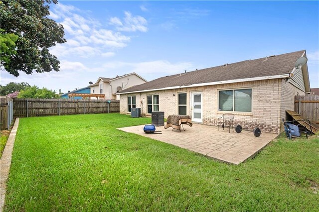 rear view of property featuring a patio, cooling unit, and a lawn