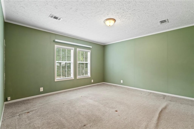 carpeted spare room featuring crown molding and a textured ceiling