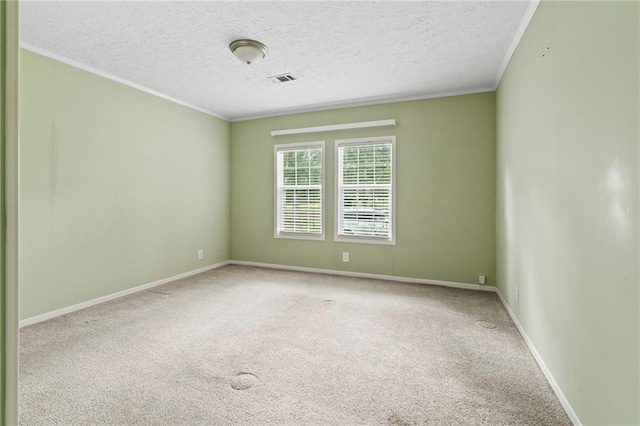 carpeted empty room featuring ornamental molding and a textured ceiling