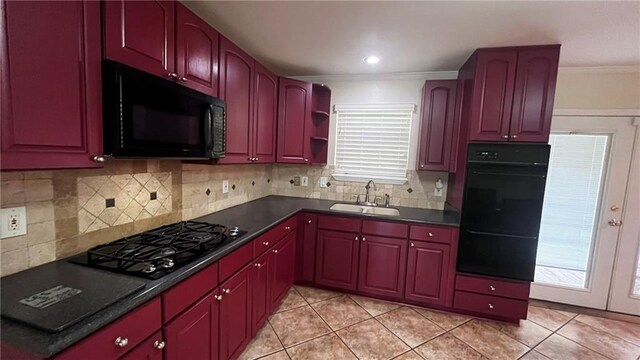 kitchen with sink, black appliances, light tile patterned floors, and backsplash