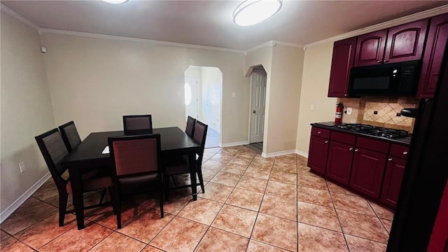 dining room featuring arched walkways, ornamental molding, light tile patterned floors, and baseboards