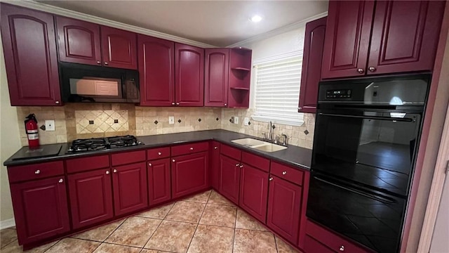 kitchen with light tile patterned floors, decorative backsplash, dark countertops, black appliances, and a sink