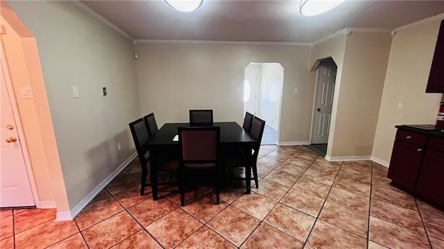 dining space featuring arched walkways, crown molding, baseboards, and light tile patterned floors