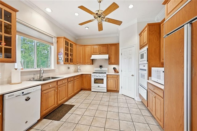 kitchen featuring light tile patterned flooring, ceiling fan, built in appliances, sink, and ornamental molding