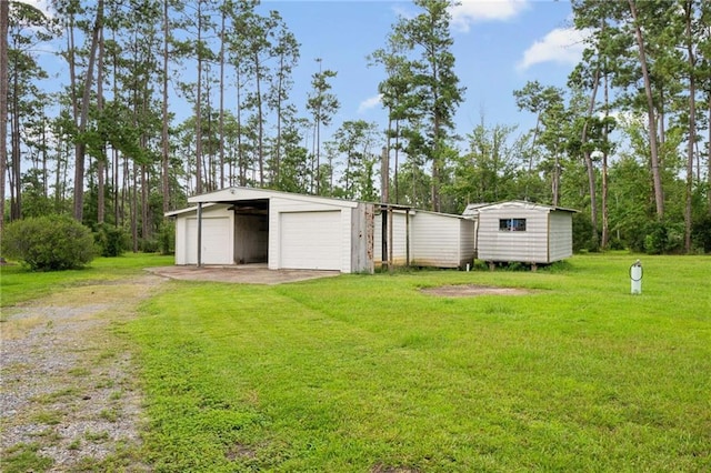 view of yard with a garage and an outbuilding