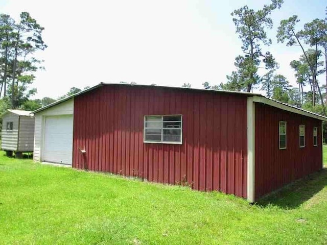 view of property exterior featuring a garage, a yard, and an outdoor structure