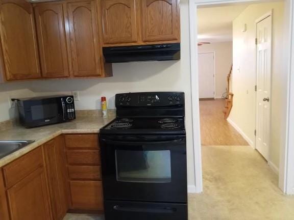 kitchen featuring range hood and black appliances