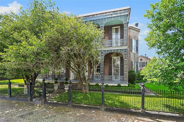 view of front of home with a balcony and a front lawn