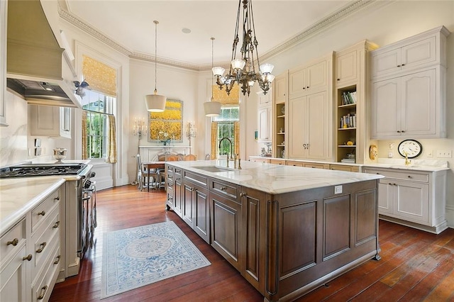 2027 Carondelet St, New Orleans, LA 70130 - kitchen with sink, hanging light fixtures, high end stainless steel range, an island with sink, and custom exhaust hood