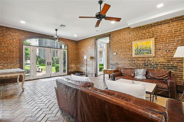 2027 Carondelet St, New Orleans, LA 70130 - living room featuring french doors, ceiling fan, brick wall, and crown molding