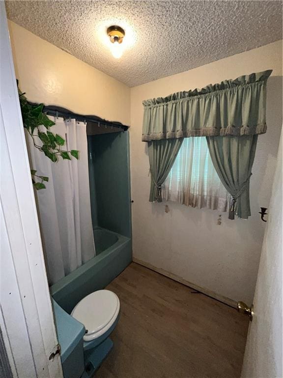 bathroom featuring a textured ceiling, wood-type flooring, toilet, and shower / bath combination with curtain