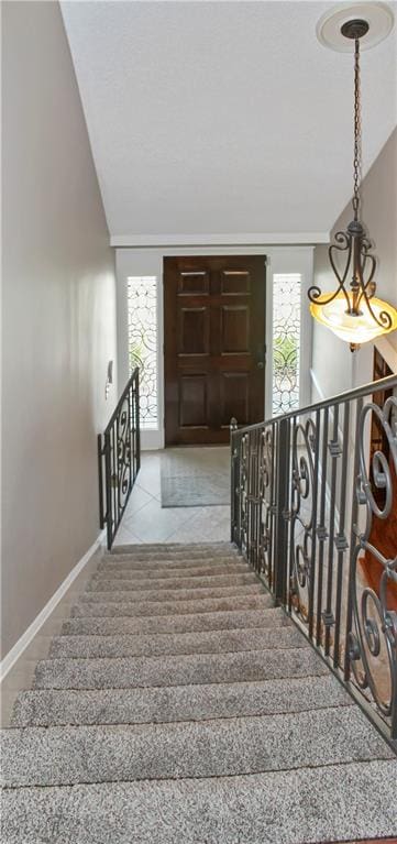 staircase featuring lofted ceiling and tile patterned flooring