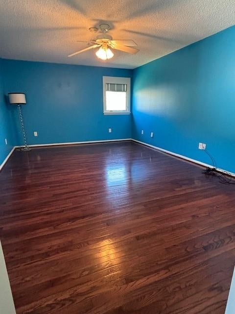 unfurnished room with ceiling fan, a textured ceiling, and dark hardwood / wood-style flooring