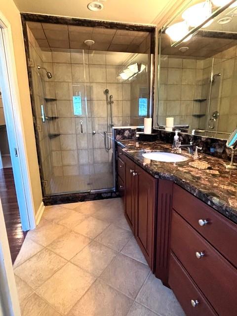 bathroom with vanity, a shower with shower door, and tile patterned flooring