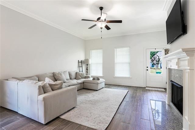 living room featuring ceiling fan, a premium fireplace, ornamental molding, and hardwood / wood-style flooring