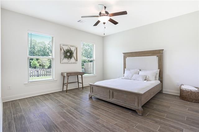 bedroom with dark hardwood / wood-style flooring, ceiling fan, and multiple windows