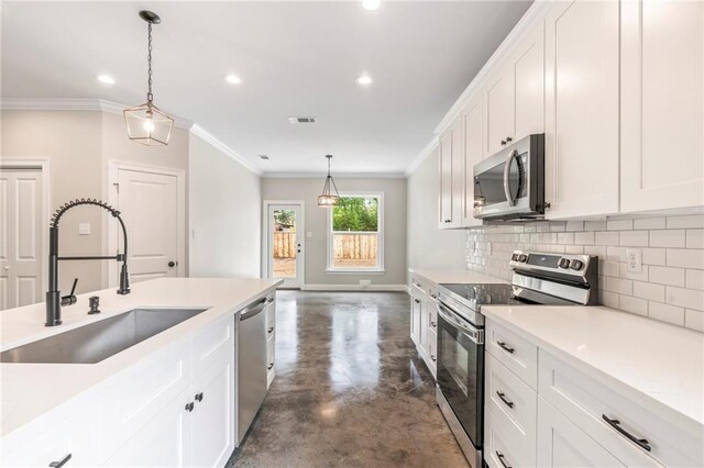 kitchen with appliances with stainless steel finishes, white cabinetry, decorative backsplash, and sink