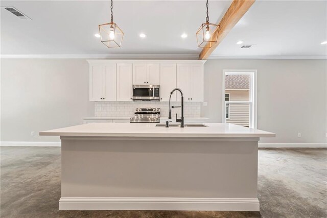 kitchen with decorative light fixtures, stainless steel appliances, decorative backsplash, sink, and a kitchen island with sink