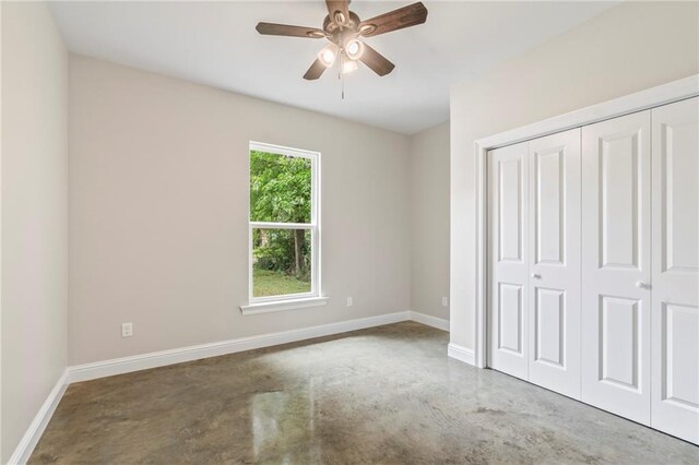 unfurnished bedroom featuring concrete flooring, ceiling fan, and a closet