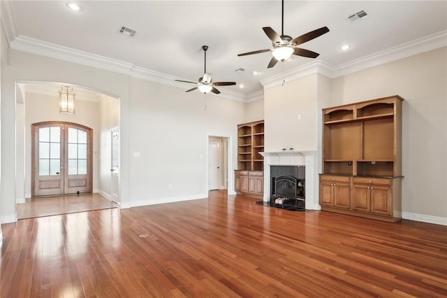 unfurnished living room featuring a tile fireplace, french doors, ceiling fan, and crown molding