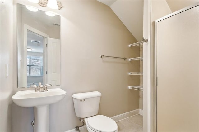 bathroom with tile patterned floors, toilet, lofted ceiling, and sink