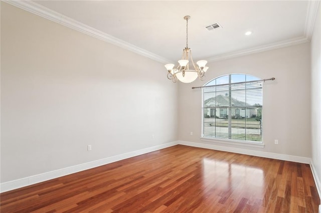 empty room featuring hardwood / wood-style floors, an inviting chandelier, and ornamental molding