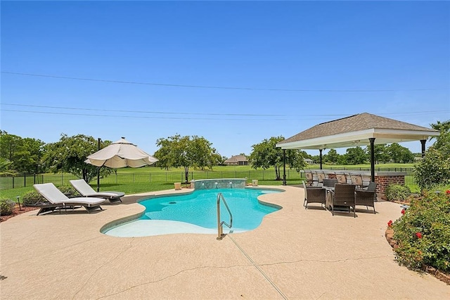 view of swimming pool featuring pool water feature, a yard, and a patio