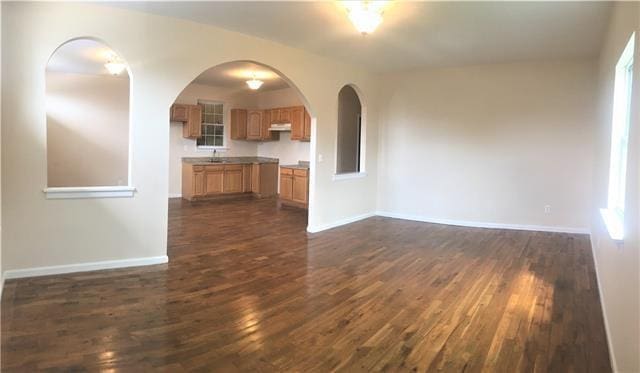 unfurnished living room with dark hardwood / wood-style floors