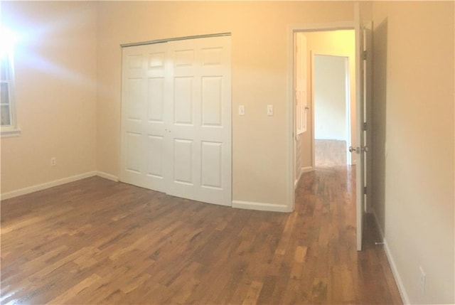 unfurnished bedroom with a closet and hardwood / wood-style floors