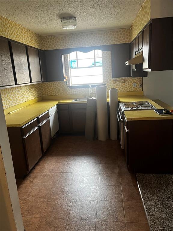 kitchen with tile patterned flooring and dark brown cabinetry