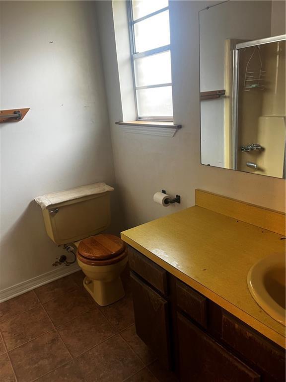 bathroom with vanity, an enclosed shower, tile patterned floors, and toilet