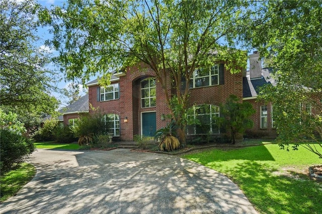 30 River Cypress Ln, Madisonville, LA 70447 - traditional-style house featuring brick siding, a front yard, and concrete driveway