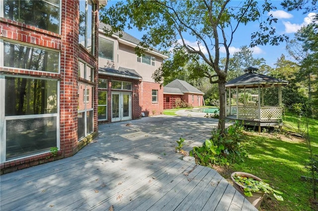 deck featuring a gazebo, a pool, and french doors