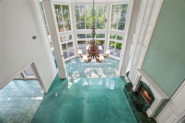 30 River Cypress Ln, Madisonville, LA 70447 - interior space featuring a chandelier, a lit fireplace, a high ceiling, baseboards, and tile patterned floors