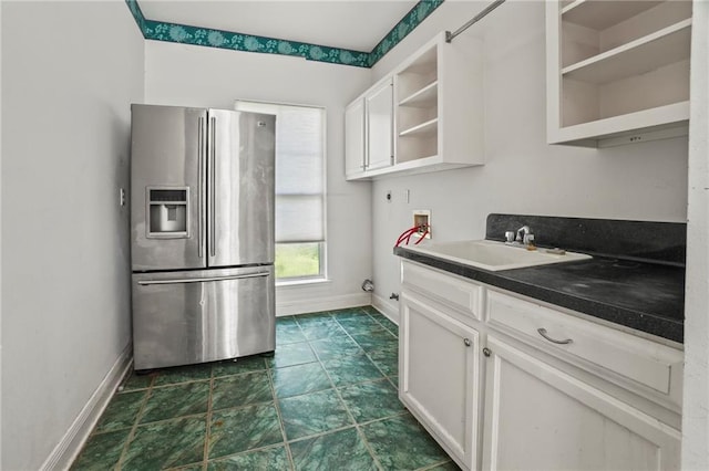 30 River Cypress Ln, Madisonville, LA 70447 - kitchen with stainless steel fridge, open shelves, baseboards, and white cabinets
