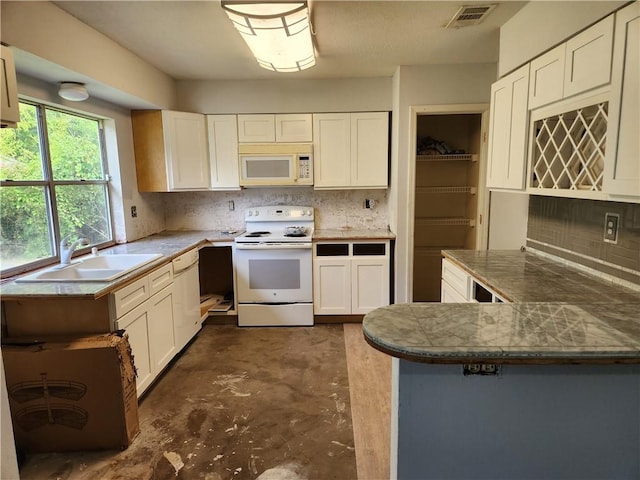 kitchen featuring kitchen peninsula, white cabinets, backsplash, sink, and white appliances