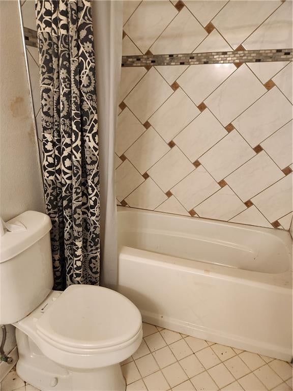 bathroom with toilet, shower / tub combo, and tile patterned flooring