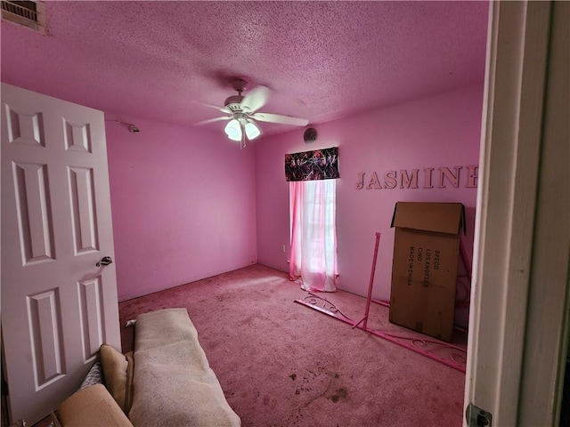 unfurnished bedroom with light carpet, a textured ceiling, and ceiling fan