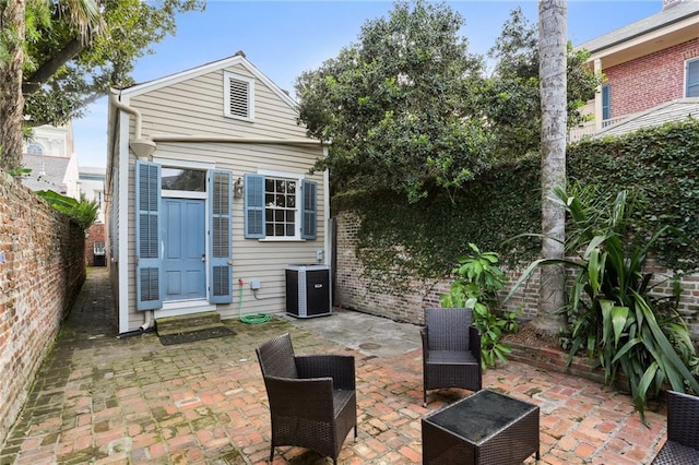 back of property with central air condition unit and a patio