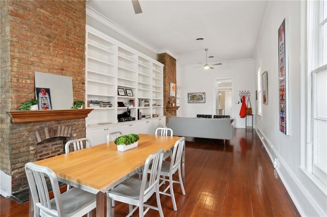 dining area with a fireplace, dark hardwood / wood-style floors, ceiling fan, and ornamental molding