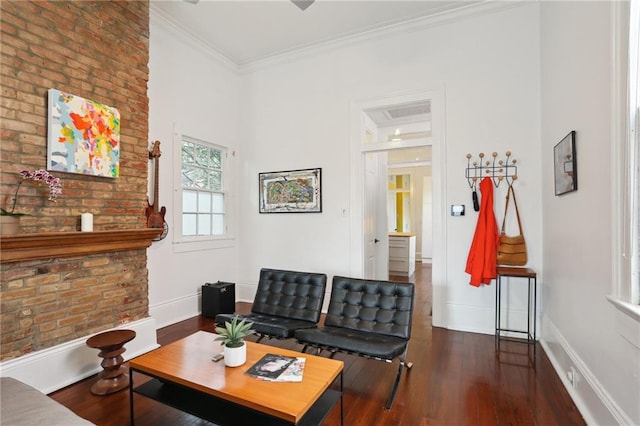 living room featuring dark hardwood / wood-style flooring, ornamental molding, and brick wall