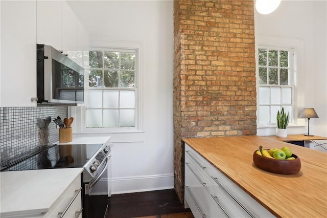 kitchen featuring white cabinets, decorative backsplash, dark hardwood / wood-style flooring, and stainless steel appliances