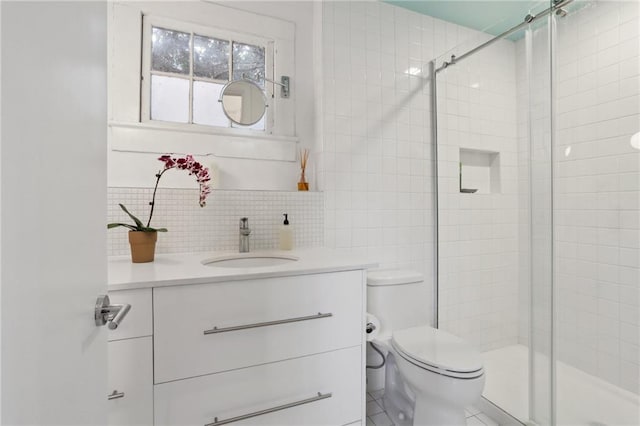 bathroom featuring vanity, backsplash, tile patterned floors, toilet, and walk in shower