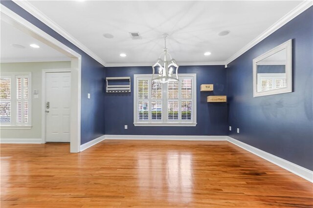 unfurnished dining area featuring a chandelier, hardwood / wood-style flooring, and ornamental molding