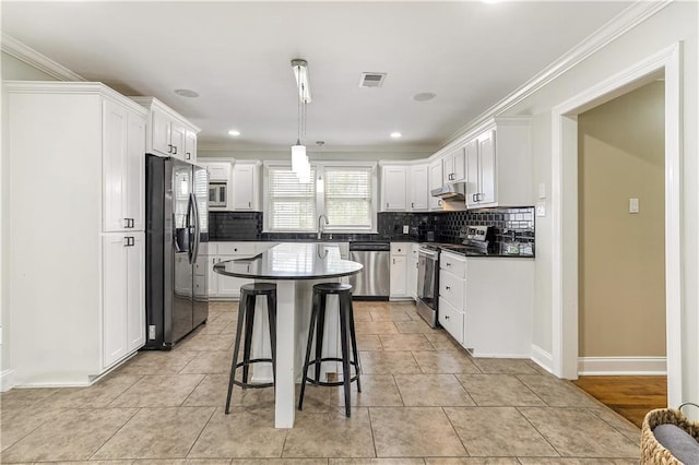 kitchen with a kitchen island, crown molding, light hardwood / wood-style flooring, and stainless steel appliances