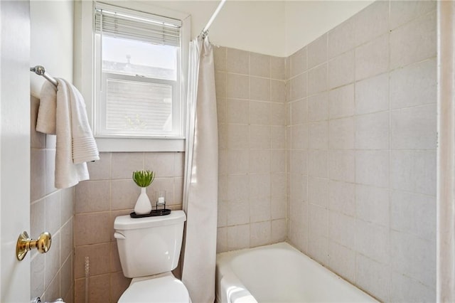 bathroom featuring tile walls, toilet, and shower / bath combination with curtain